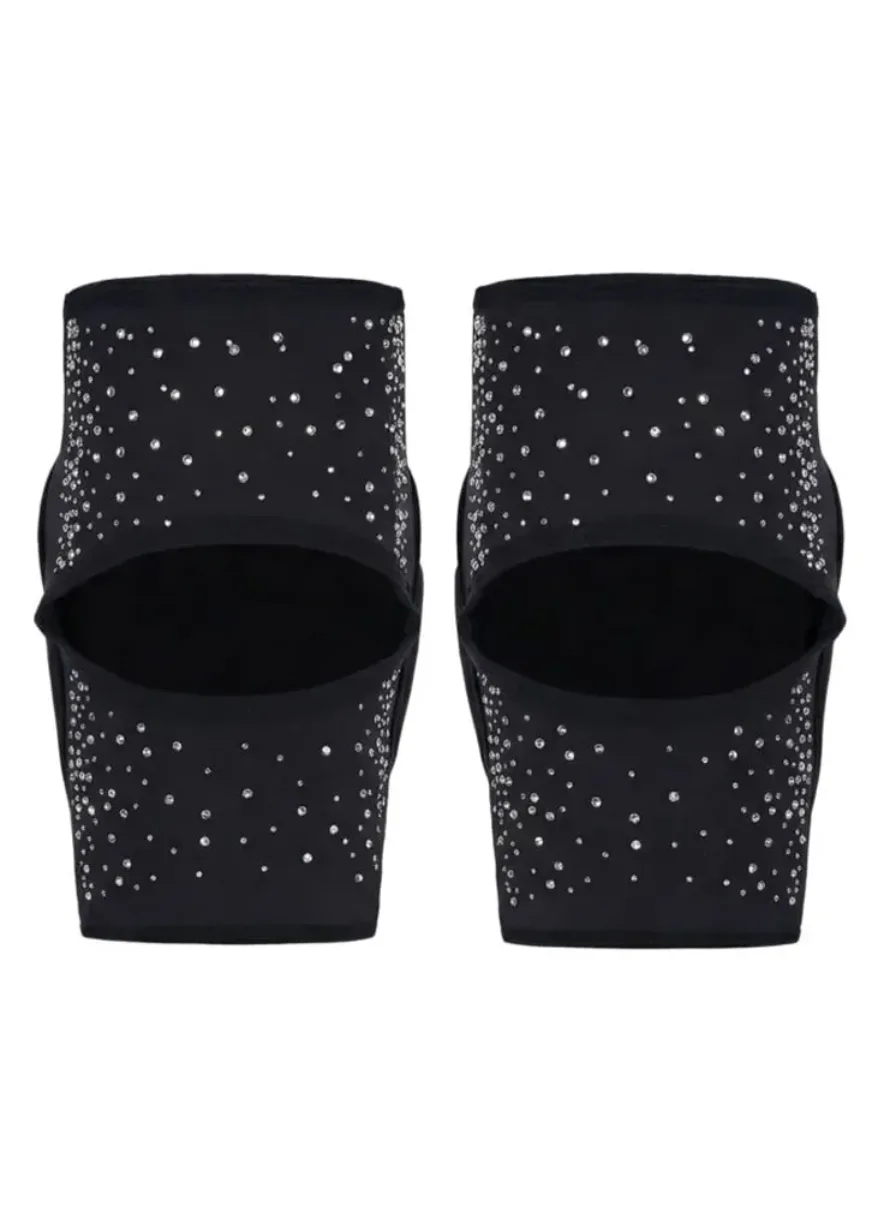 Pair of black slip-on sandals with rhinestone embellishments behind open toes or straps, sparkling detail visible across the footwear coasted in crystals